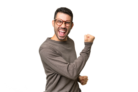 Young handsome caucasian man over isolated background celebrating a victory