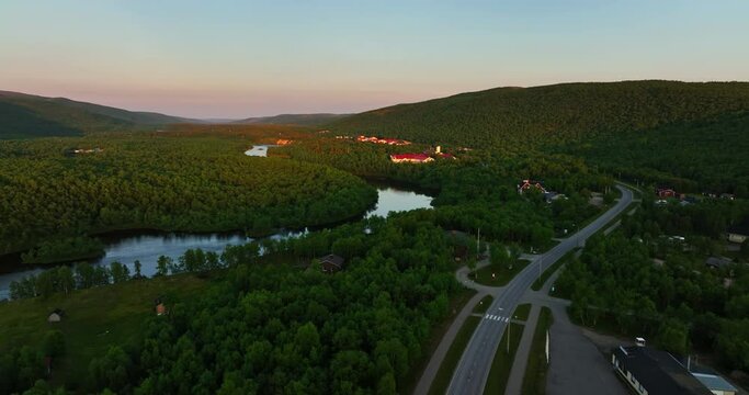 Aerial view over the Utsjoki town and the Stuorraluoppal river, midnight sun in Lapland, Finland