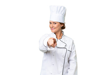 Middle-aged chef woman over isolated background points finger at you with a confident expression