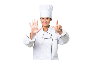 Middle-aged chef woman over isolated background counting seven with fingers