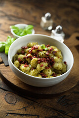 Homemade potato gnocchi with pesto and sausage 