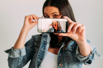 Close up of beautiful woman taking photo with smartphone, selfie.