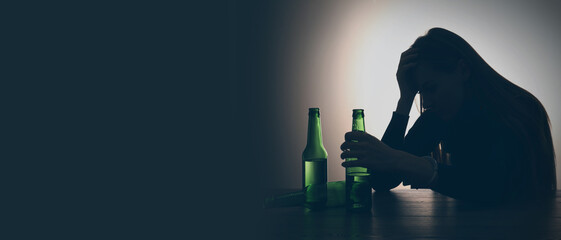 Suffering from hangover. Woman with alcoholic drink at table against black background, space for...