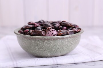 Bowl with dry kidney beans on table, closeup