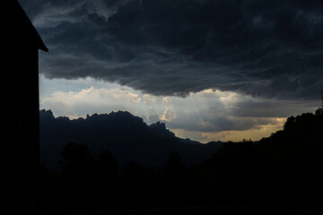 Stormy sky with silhouette of catalan farmhouse buildings