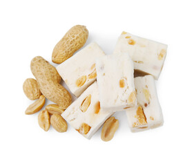 Pieces of delicious nougat and nuts on white background, top view