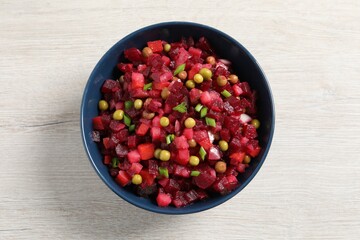 Bowl of delicious fresh vinaigrette salad on white wooden table, top view