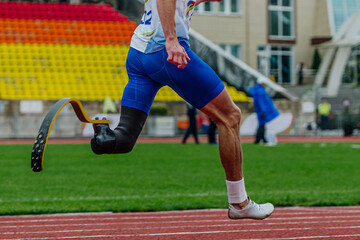 close-up male para athlete on limb deficiency running track stadium, summer para athletics championships