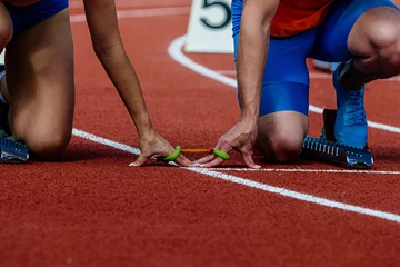 Zelfklevend Fotobehang female blind para athlete runner with male guide in starting blocks ready running race, summer para athletics championships © sports photos