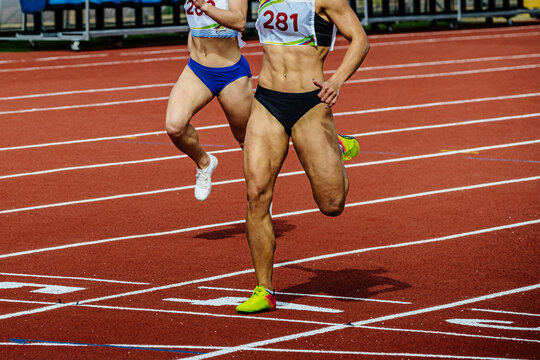 female runner athlete running finish line sprint race track stadium, summer athletics championships