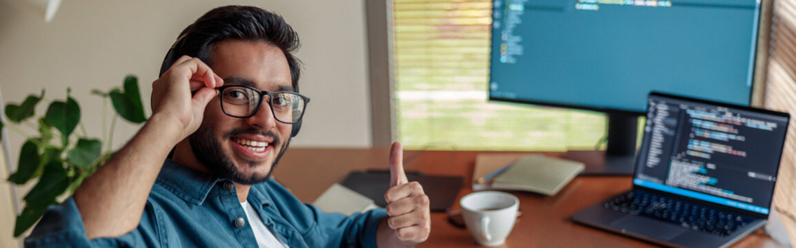 Man in headphones freelance data scientist work remotely at home and looking at camera - Powered by Adobe