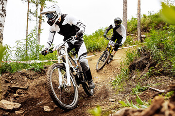 two racer athlete riding downhill training race in mountain bike, sports summer games
