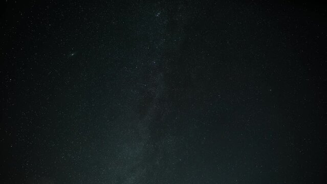 Time lapse white clouds are flying against the background of the night starfall and the Milky Way. Cg