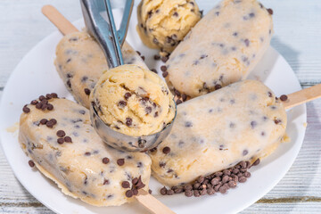 Edible raw cookie dough popsicle ice cream. Homemade popsicle lollipops with frozen edible raw cookie dough and chocolate chips, trendy american summer dessert