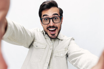 Closeup portrait man takes selfie with glasses smile with teeth joy on white isolated background, fashionable clothing style, copy space, space for text