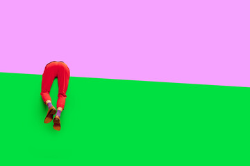 Male legs in red pants and classical shoes over vivid purple and green background. Empty space to...