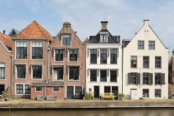 View on a row of canal houses on Het Grootdiep in Dokkum Friesland The Netherlands on a sunny day in spring. Dokkum is one of the Frisian eleven cities.   - obrazy, fototapety, plakaty