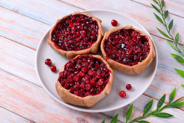 Kalitka pie, Karelian pasty, with cowberry on white plate - obrazy, fototapety, plakaty