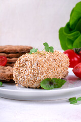 Caboc, Scottish soft cheese made of fat milk, in oat grains served on the plate