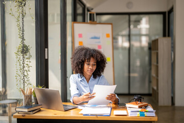 Black woman sitting in front of her considering work, office work Business woman sitting thinking work concept.