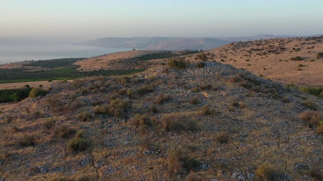 sunrise over the golan heights and lake of galilee in israel. drone flying over a hill in the galilee towards the sunrise. morning views of the sea of galilee from the air. israeli sunrise.