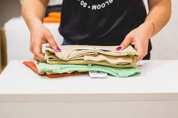 manos chicas ordenando camisetas para enviar paquete online 