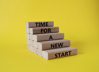 Time for a new start symbol. Wooden blocks with words Time for a new start. Beautiful yellow...