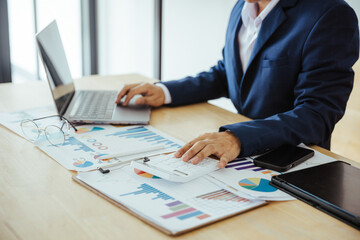 Close up of business analysis, investment and finance concept. Businessman, accountant calculating business report. market information Financial graph while working on laptop computer with spreadsheet