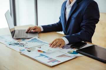 Close up of business analysis, investment and finance concept. Businessman, accountant calculating business report. market information Financial graph while working on laptop computer with spreadsheet