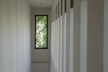 Modern white narrow hallway with windows on the side wall
