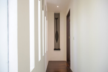 Modern white narrow hallway with windows on the side wall