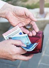 Pink purse, banknotes and coins in female hands, selective focus.