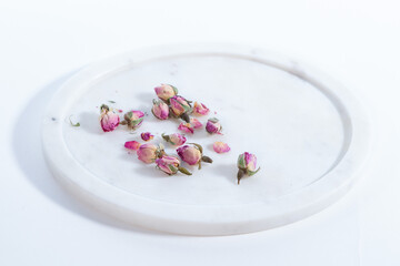 Obraz na płótnie Canvas small roses dried on a marble plate