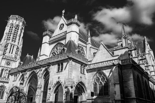 The historic Saint-Germain-l'Auxerrois Gothic style church in France, Black and white Paris cityscape with dramatic clouds