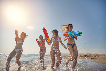 Group of cheerful friends having a water gun fight