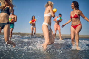 Blurred shot of group of friends playing with water guns. Young caucasian man and women on summer holiday. Fun, play, holiday, lifestyle concept.