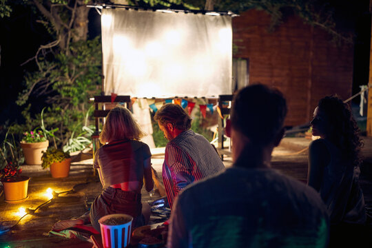 .Friends enjoying together outdoor at night and watching movie