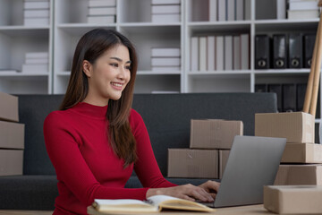 Startup small business entrepreneur SME, asian woman packing cloth in box. Portrait young Asian small business owner home office, online sell marketing delivery, SME e-commerce telemarketing concept.