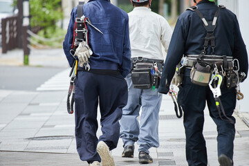 朝の街で歩く建築現場の作業員の姿