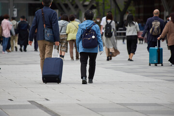東京駅の広場のスーツケースを持っている観光客の姿