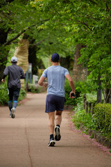 初夏の皇居周辺の道でランニングしている人々の姿