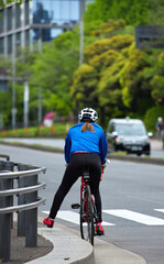 Naklejka premium 東京の街の道路で自転車を乗って運動している女性の姿