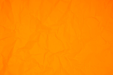 The Orange color crumpled paper texture background