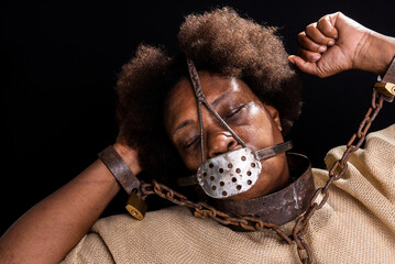 Portrait of a black woman in chains with an iron mask on her face representing the slave Anastacia....