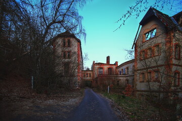 Entrance to long abandoned historic sanatorium in Germany in dusk - obrazy, fototapety, plakaty