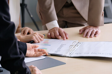 Businessman hand pointing and holding documents at meeting.