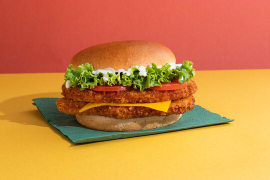 Fish burger with tomatoes, cheese slices and fresh lettuce