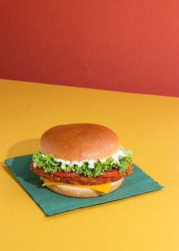 Fish burger with tomatoes, cheese slices and fresh lettuce