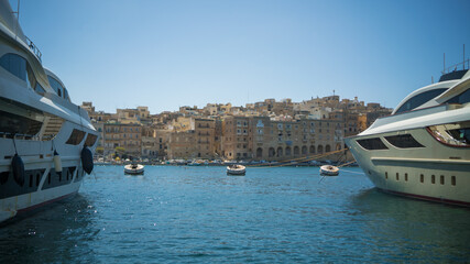 2 yachts and 3 buoys in the sea in 3 cities in Malta  