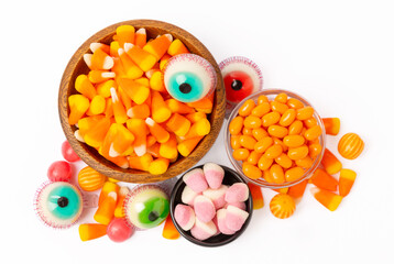Halloween corn, jelly eyes, sugar skull and pumpkin candy isolated on white background. Classic sweet treats for Halloween. Halloween holiday concept with corn and jack o lantern.